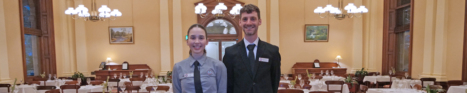 two people standing in a dining room