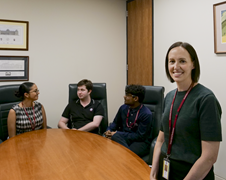 Group of people around table, one in foreground
